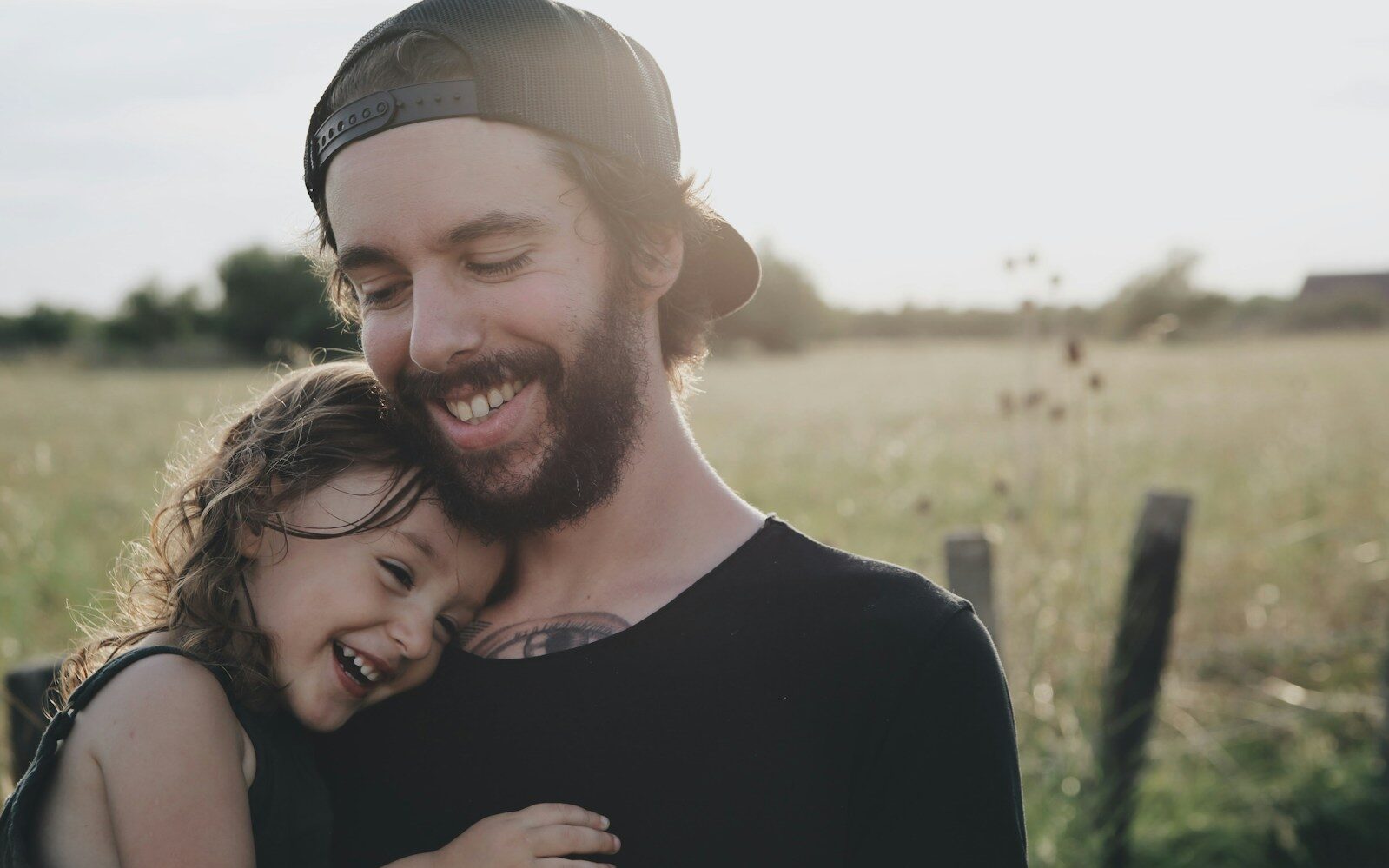 man carrying daughter in black sleeveless top